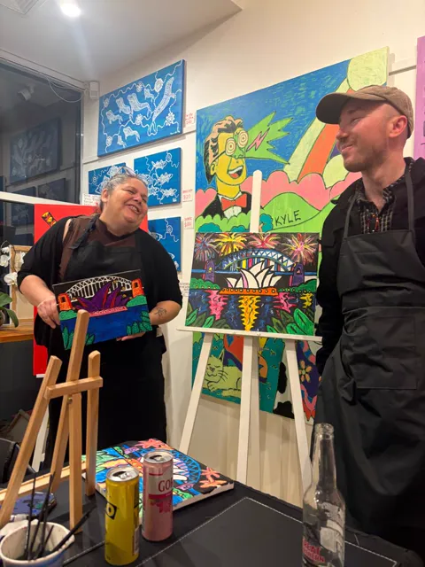 The artist laughing with a guest at the end of the night
